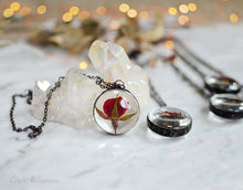 Load image into Gallery viewer, A pendant holds hand-picked tiny locally sourced rosebuds. They were pressed and dehydrated to preserve the natural shape and color, then carefully set in a glass in a stained glass technique. They'll last a lifetime for you to admire!