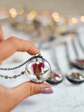 Load image into Gallery viewer, A pendant holds hand-picked tiny locally sourced rosebuds. They were pressed and dehydrated to preserve the natural shape and color, then carefully set in a glass in a stained glass technique. They'll last a lifetime for you to admire!