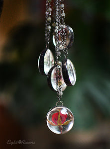 A pendant holds hand-picked tiny locally sourced rosebuds. They were pressed and dehydrated to preserve the natural shape and color, then carefully set in a glass in a stained glass technique. They'll last a lifetime for you to admire!